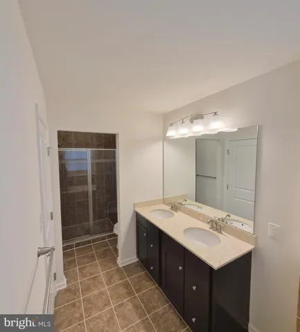 a bathroom with a shower sink and mirror