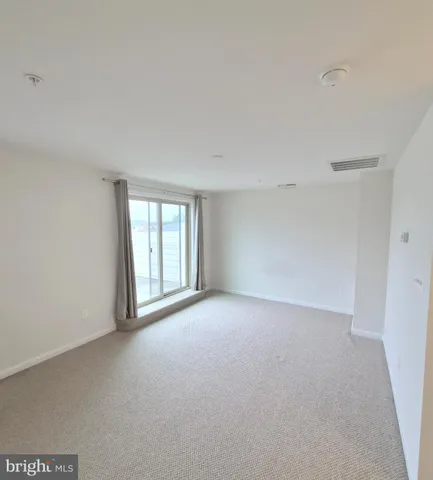 a view of a big room with windows and chandelier fan