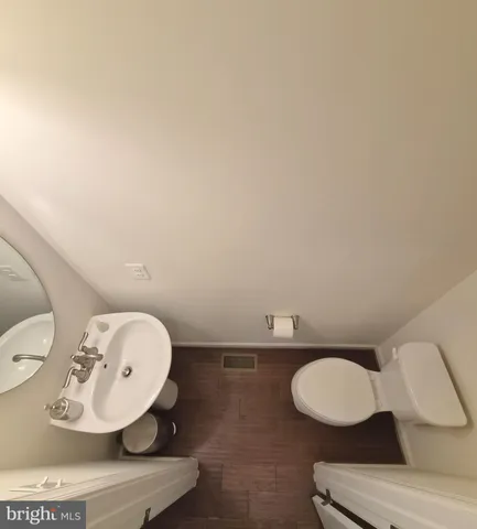 a bathroom with a toilet mirror and sink