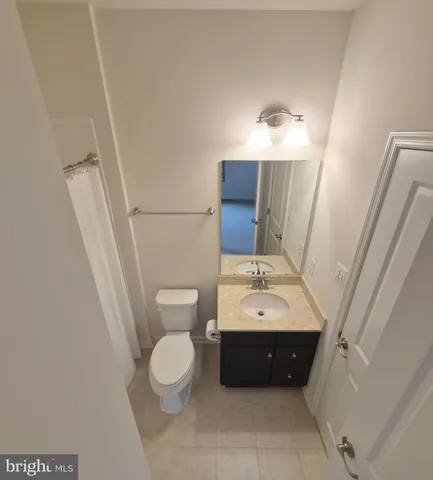 a bathroom with a sink vanity granite toilet and a mirror