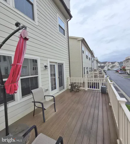 a balcony with wooden floor table and chairs