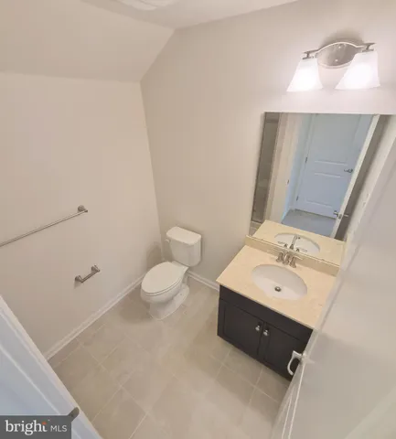 a spacious bathroom with a toilet a sink and mirror