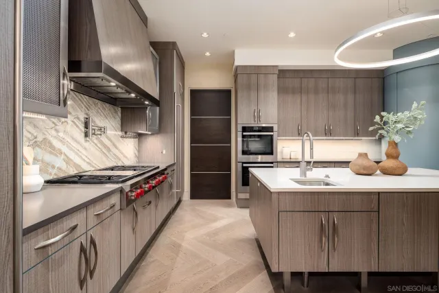 a kitchen with kitchen island granite countertop a sink stainless steel appliances and cabinets