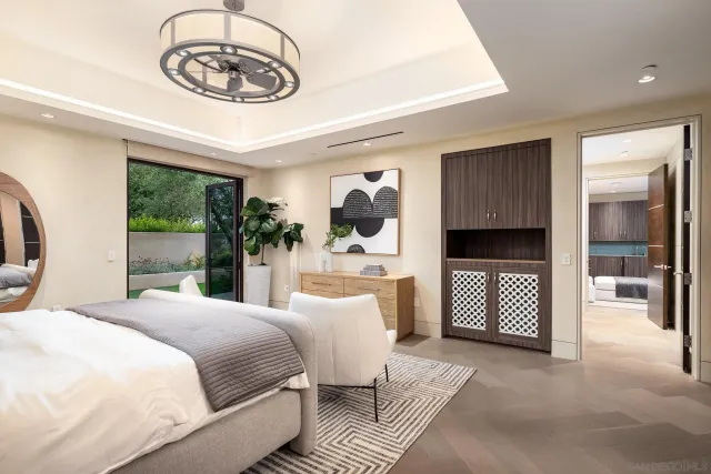 a bedroom with a large bed and a chandelier