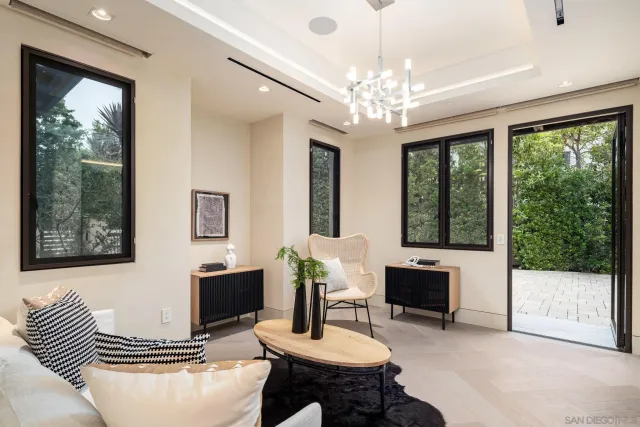 a living room with furniture a chandelier and a large window