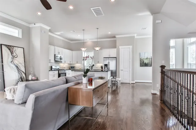 a living room with furniture a wooden floor and a large window