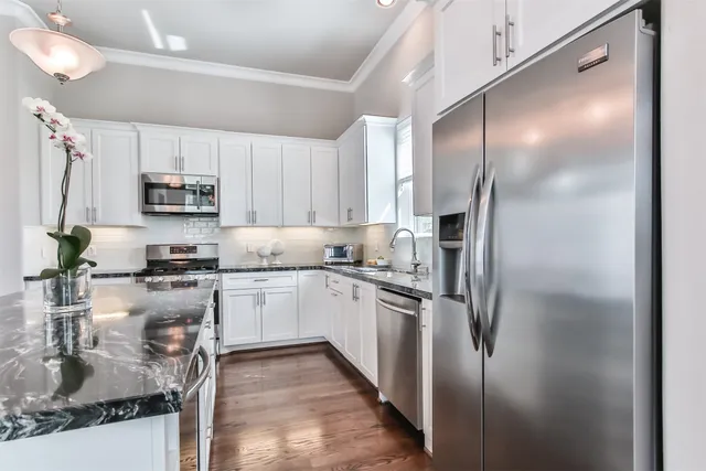 a kitchen with a refrigerator a microwave a sink and cabinets