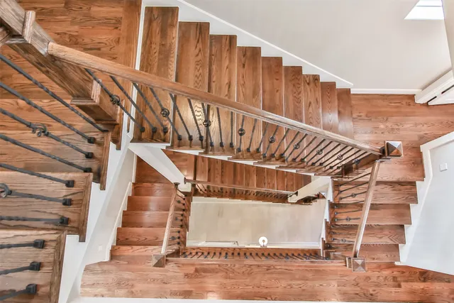 a view of a hallway with wooden floor and stairs