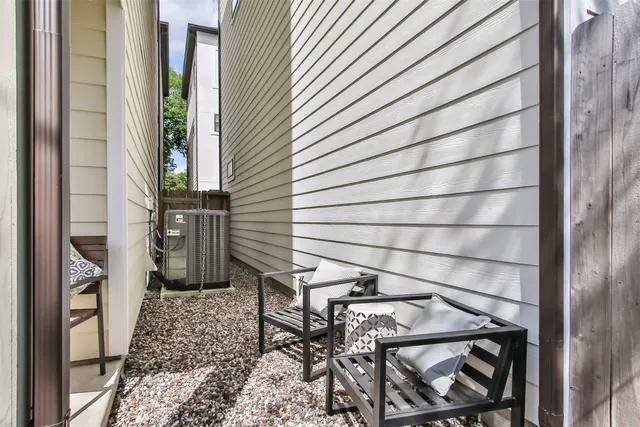 a view of a white building among the street with flower plants