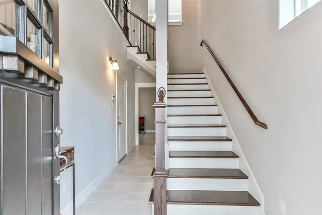 a view of staircase with lots of frames on wall and a window