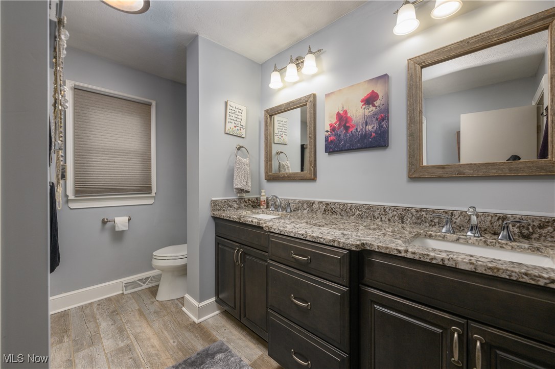 2856 Shellhart Road Barberton, OH 44203 - Photo 22 of 27 Bathroom with double vanity and wood finished floors