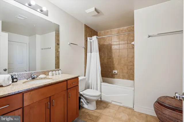 a bathroom with a granite countertop sink toilet tub and shower