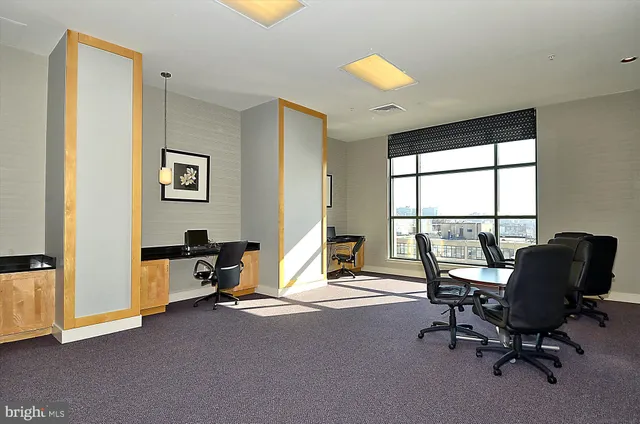 a view of a workspace with furniture and a window