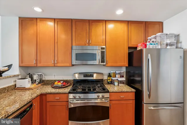 a kitchen with stainless steel appliances granite countertop a refrigerator stove and sink