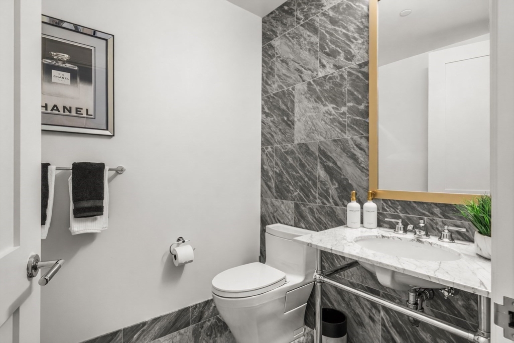 240 Devonshire Street, Unit 3701 Boston, MA 02110 - Photo 14 of 40 a bathroom with a granite countertop toilet sink and mirror