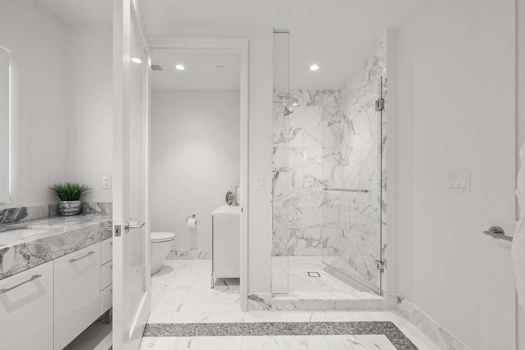 240 Devonshire Street, Unit 3701 Boston, MA 02110 - Photo 24 of 40 a bathroom with a granite countertop sink a toilet and shower