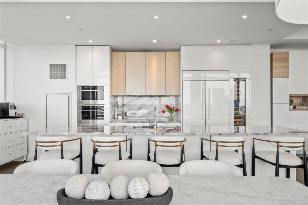 240 Devonshire Street, Unit 3701 Boston, MA 02110 - Photo 9 of 40 a kitchen with counter space dining table and chairs