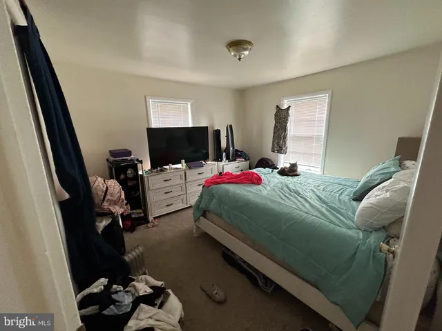 a bedroom with bed and wooden floor
