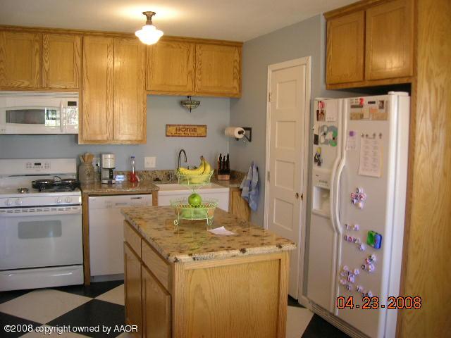 58 Hunsley Road Canyon, TX 79015 - Photo 3 of 10 a kitchen with a sink a stove a refrigerator and cabinets