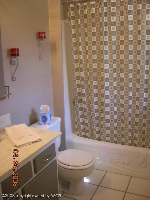 58 Hunsley Road Canyon, TX 79015 - Photo 6 of 10 a bathroom with a sink a toilet and shower curtain
