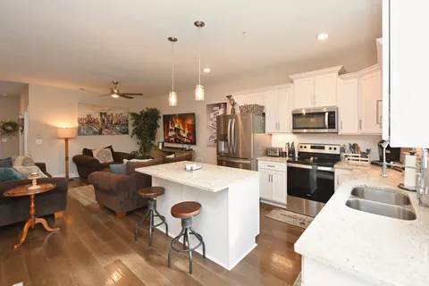 a kitchen with a sink a counter top space stainless steel appliances and cabinets