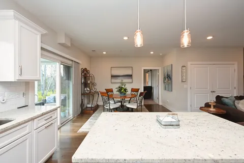 a large kitchen with kitchen island a large counter space dining table and stainless steel appliances