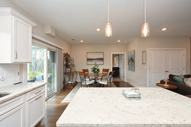 a large kitchen with kitchen island a large counter space dining table and stainless steel appliances