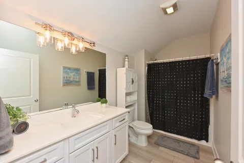 a bathroom with a sink a toilet a shower and a mirror