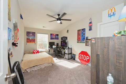 a bed room with a bed a couch and a book shelf