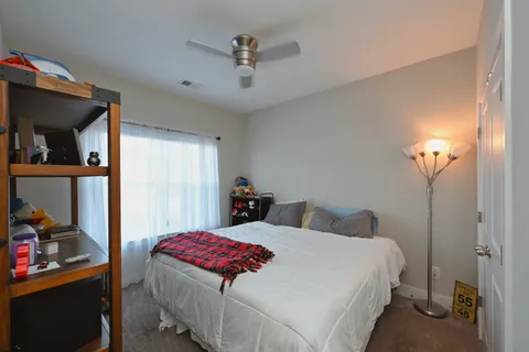 a bedroom with a bed and a lamp on the dresser