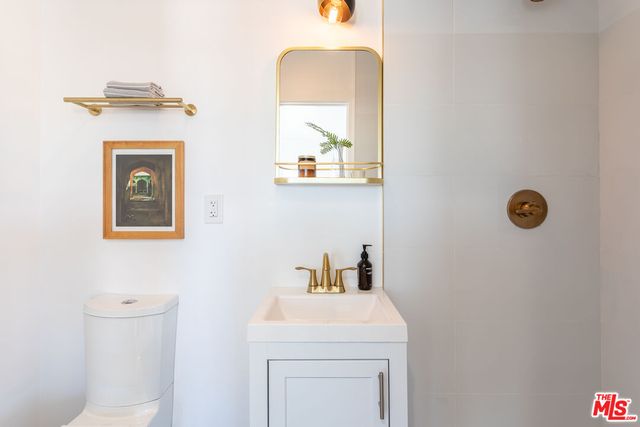 a bathroom with a sink a mirror and toilet
