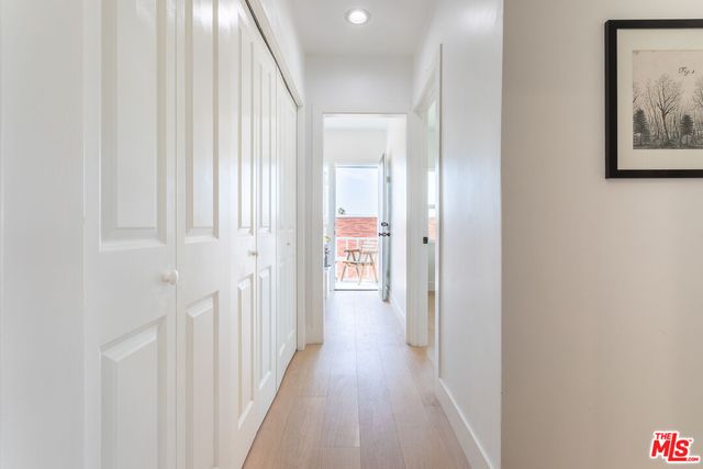 a view of a hallway with wooden floor and closet