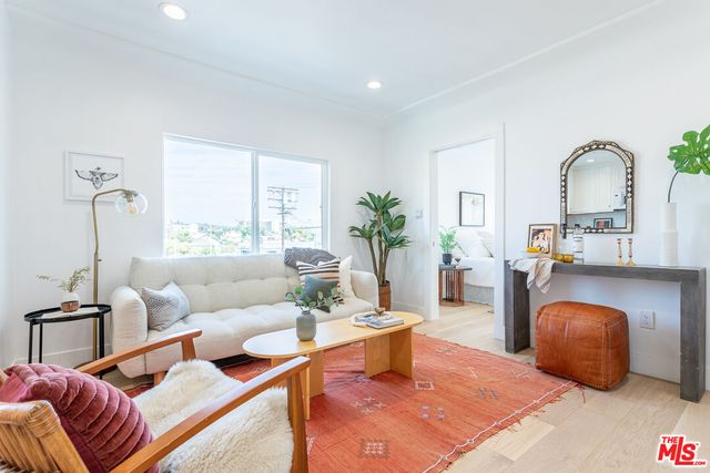 a living room with furniture a rug and a large window