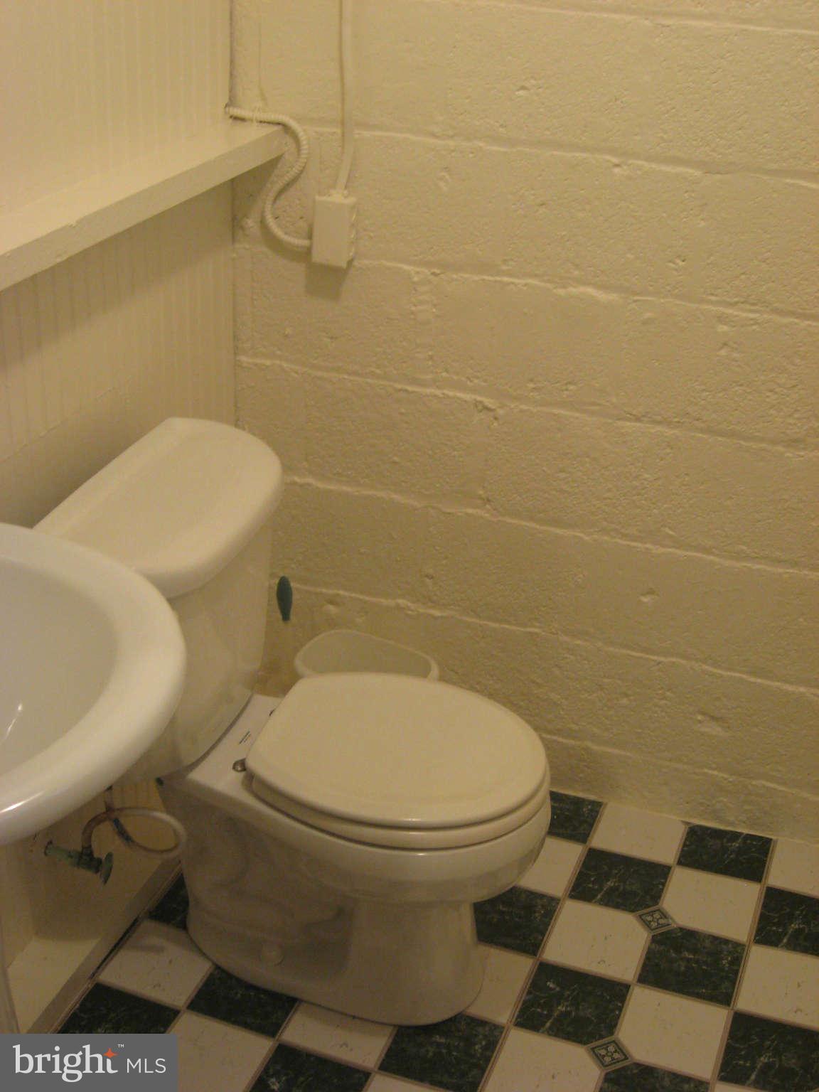 9015 Bradford Road Silver Spring, MD 20901 - Photo 21 of 25 a white toilet sitting next to a bathroom sink