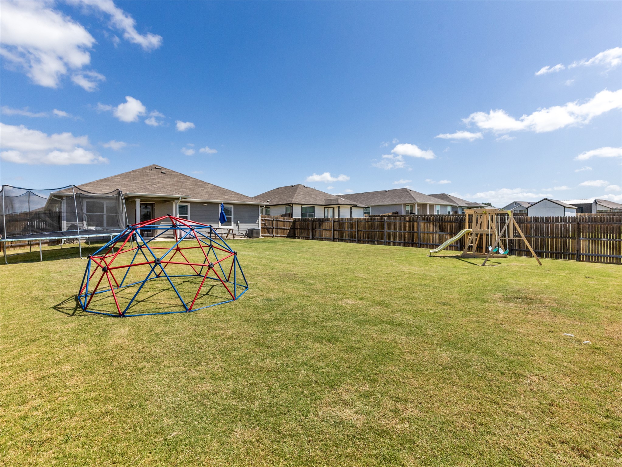 439 Hunter Loop Bertram, TX 78605 - Photo 22 of 23 A spacious, green yard, fully fenced for privacy, offers ample room for outdoor recreation.