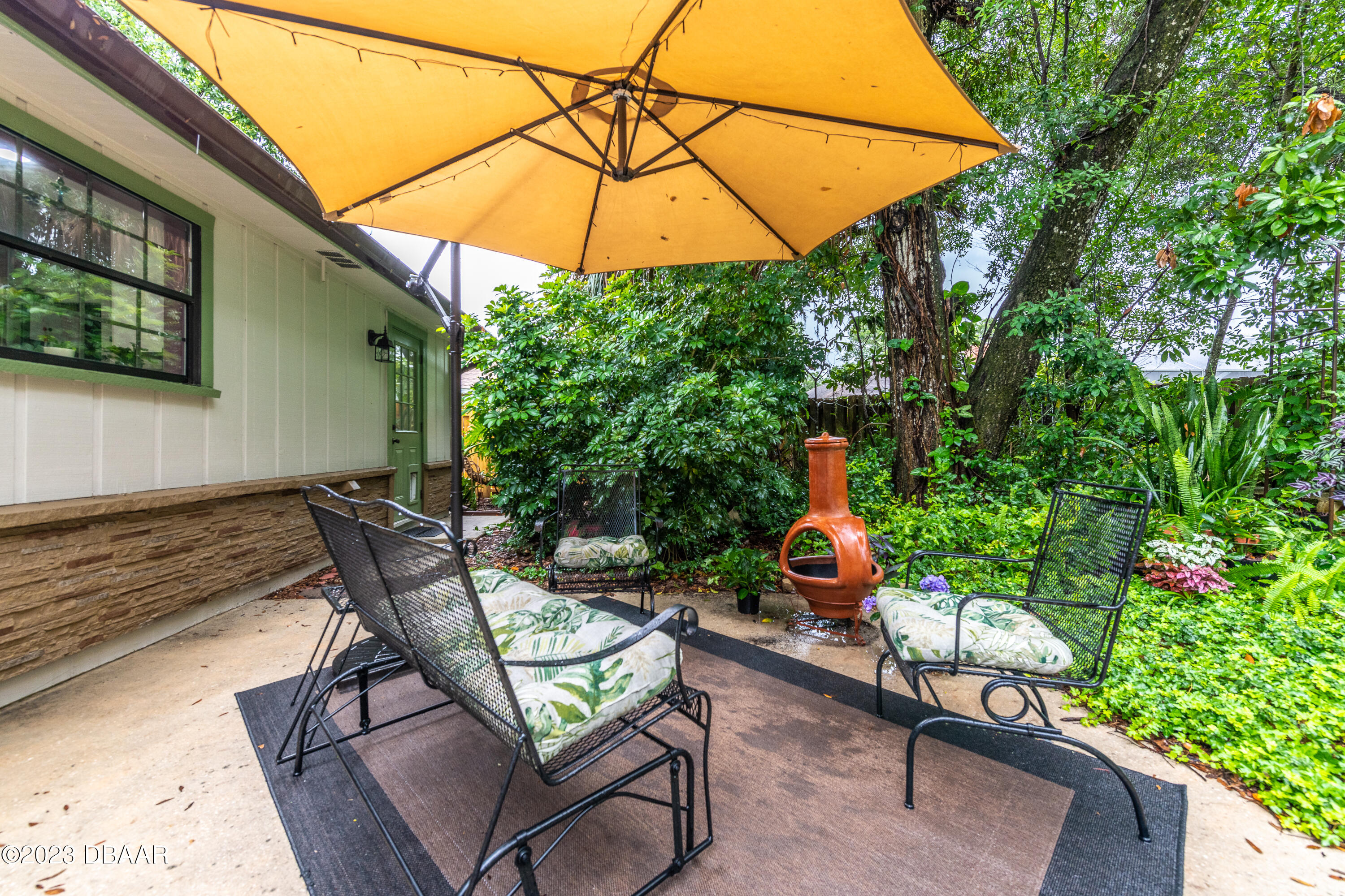 11 Eagle Drive Ormond Beach, FL 32174 - Photo 21 of 25 a backyard of a house with table and chairs under an umbrella