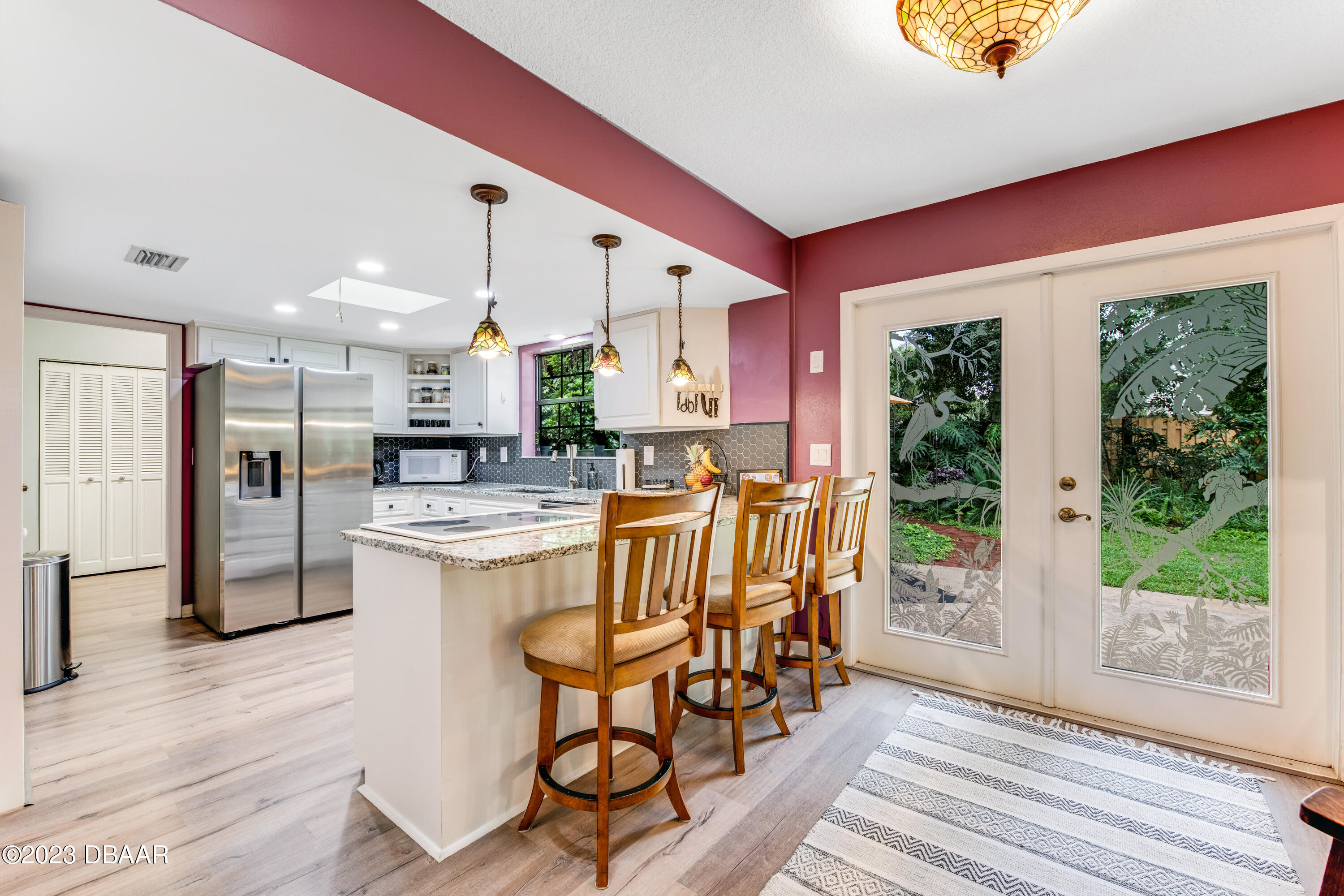11 Eagle Drive Ormond Beach, FL 32174 - Photo 7 of 25 a kitchen with stainless steel appliances granite countertop a stove a refrigerator and a dining table with wooden floor