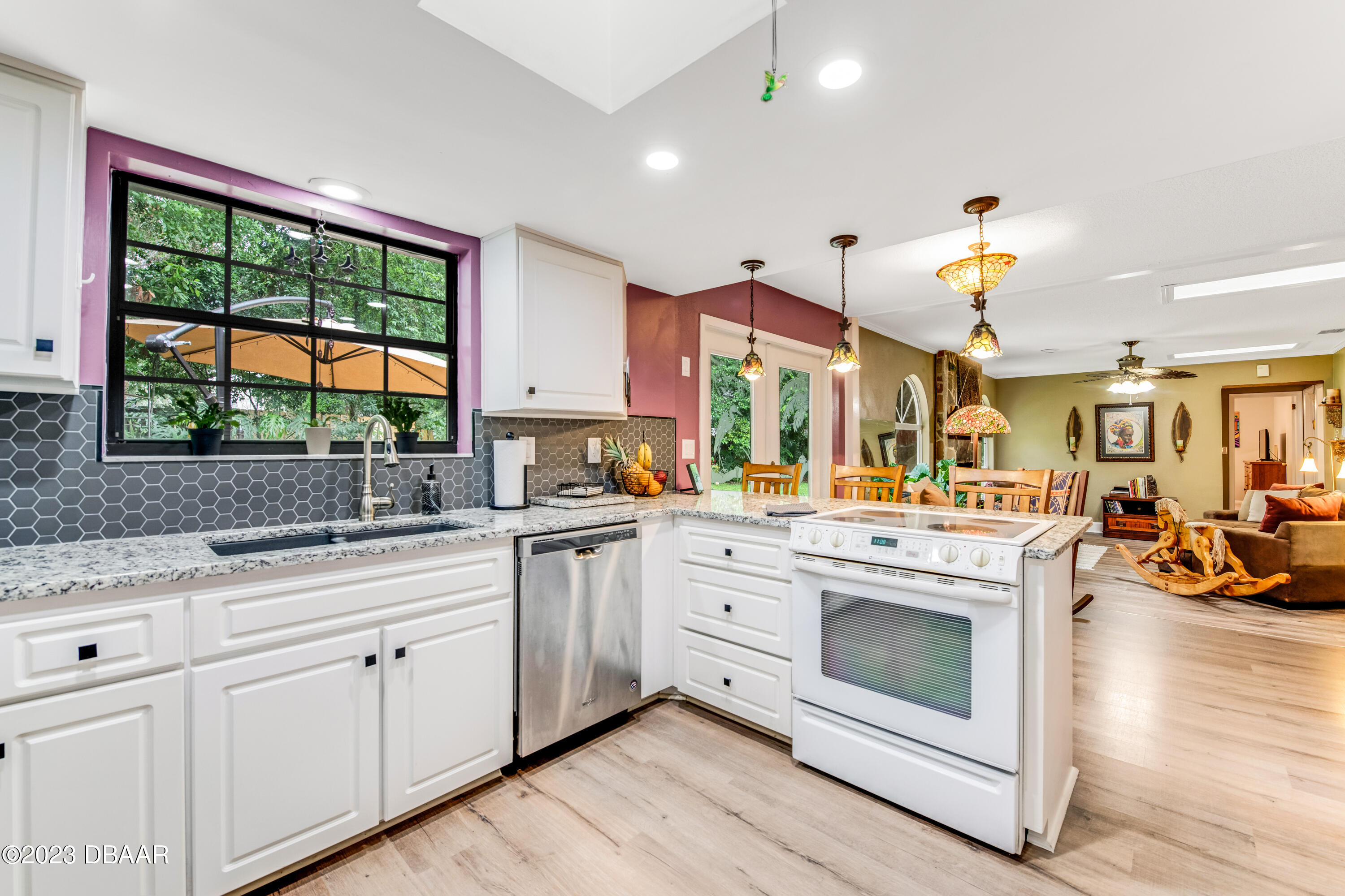 11 Eagle Drive Ormond Beach, FL 32174 - Photo 8 of 25 a kitchen with stainless steel appliances granite countertop a stove a sink and white cabinets with wooden floors