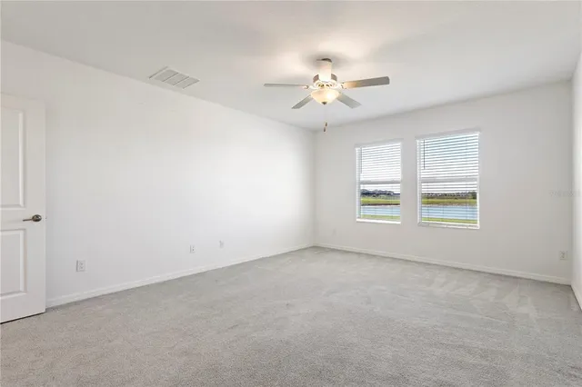 an empty room with a window and a fan