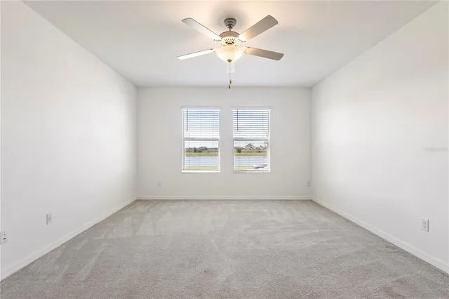 an empty room with a window and a fan