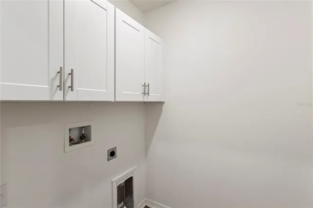 a view of cabinets with stainless steel appliances wooden floor and a window
