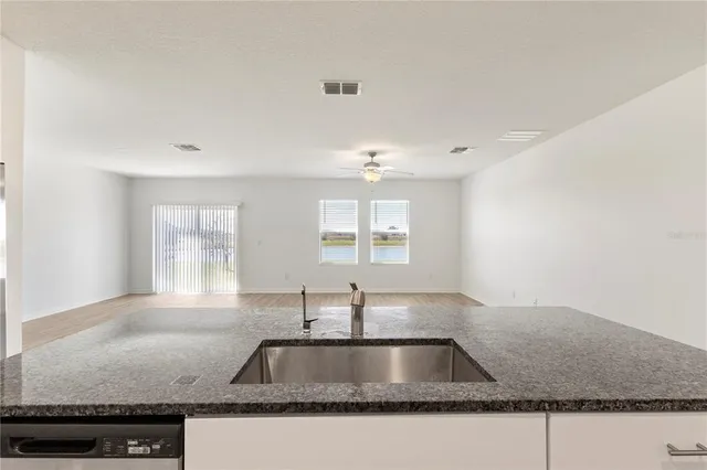 a kitchen with granite countertop a sink and a window