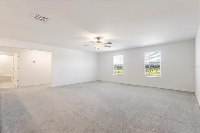 an empty room with a window and a ceiling fan