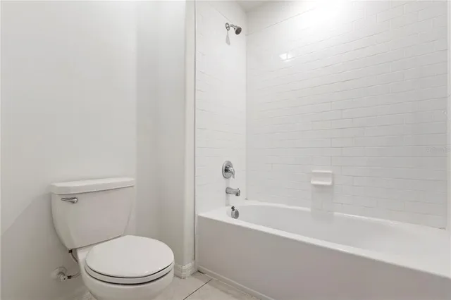 a white toilet sitting next to a bath tub