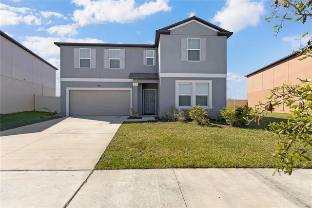 a front view of a house with a yard and garage