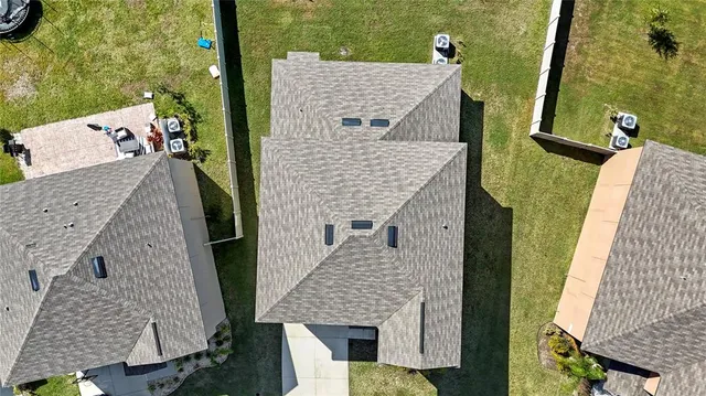 an aerial view of a house with a yard