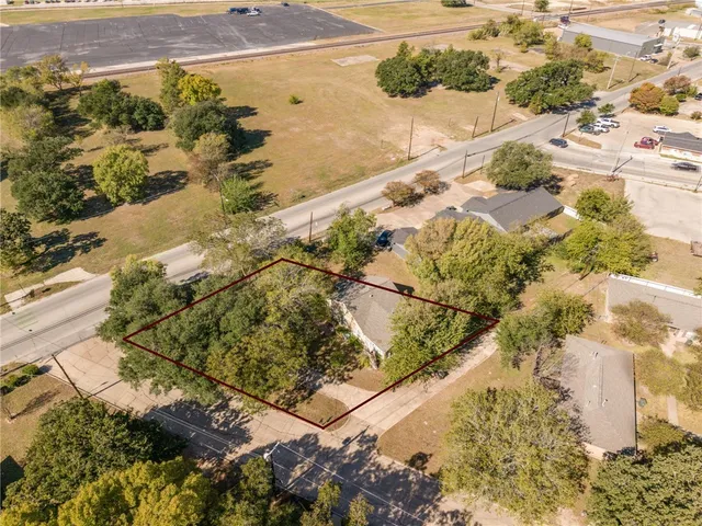 a view of a house with potted plants and a small yard