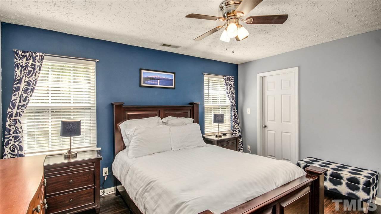 5720 Forest Point Road Raleigh, NC 27610 - Photo 13 of 22 a bedroom with a bed and a chandelier