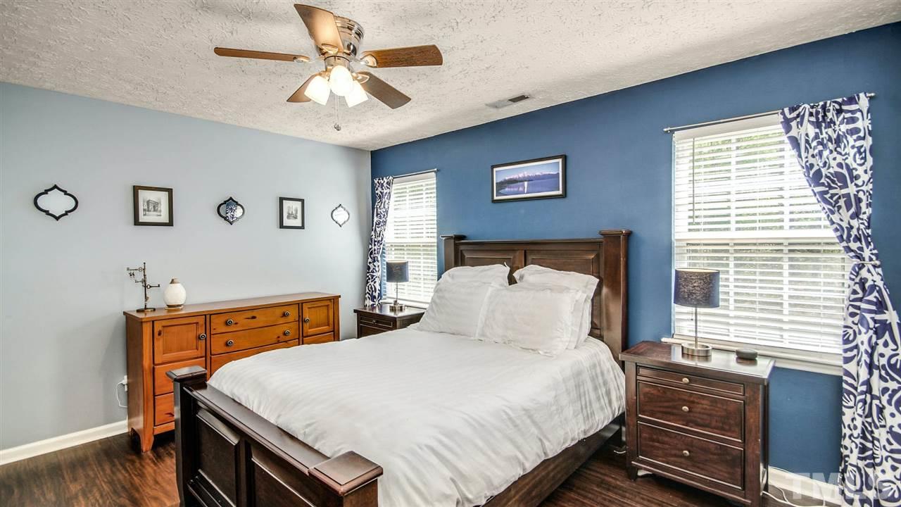 5720 Forest Point Road Raleigh, NC 27610 - Photo 14 of 22 a bedroom with a bed and a chandelier