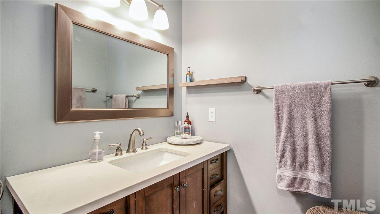 5720 Forest Point Road Raleigh, NC 27610 - Photo 15 of 22 a bathroom with a sink vanity and a mirror